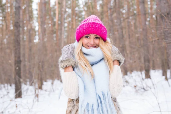 雪に覆われた森の中のピンクのセーターで魅力的なブロンドの女性は笑っている人、冬美のコンセプト- — ストック写真