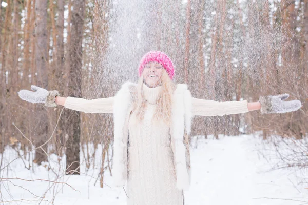 Stagione, svago e concetto di persone: la giovane donna è felice e getta neve nella natura invernale — Foto Stock