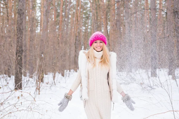 Щаслива молода жінка грає зі снігом у засніженому лісі на відкритому повітрі — стокове фото