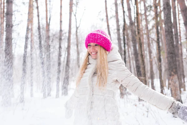 Joyeux jeune femme joue avec une neige à la forêt enneigée en plein air Images De Stock Libres De Droits