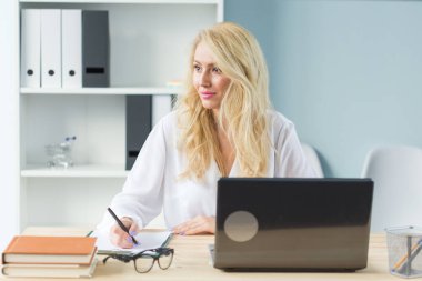 İş, teknoloji ve insan kavramı - laptop çalışma ve gülümseyen genç sarışın kadın