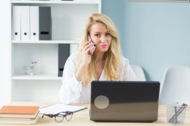 Çalışma, iş, teknoloji ve insan kavramı - laptop izliyor ve telefonu konuşurken genç kadın