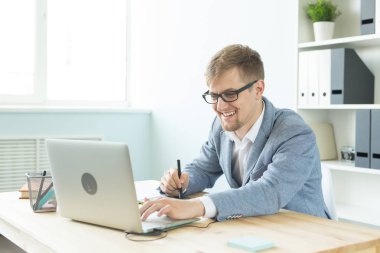 Tasarımcı, sanatçı ve web tasarım konsepti - ofiste dijital kalem tablet ve dizüstü bilgisayar kullanan genç adam portresi