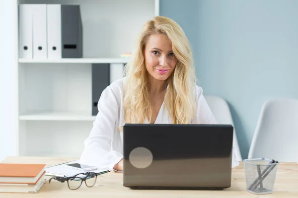 Concept technologie, travail et personnes - Belle femme blonde assise à son bureau et travaillant sur un ordinateur portable — Photo