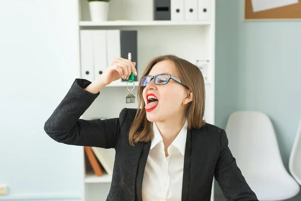 Affari, agente immobiliare, scherzo e concetto immobiliare - Ritratto di divertente attraente donna sorridente che tiene le chiavi — Foto Stock