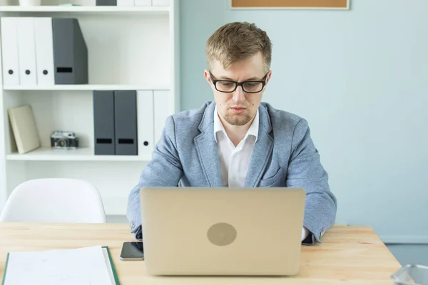 Negocios, tecnologías y personas concepto - Hombre guapo que trabaja en la oficina en el ordenador portátil — Foto de Stock