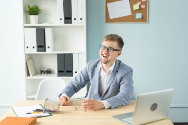 Ofis, iş adamları, sonu kavramı - Yöneticisi çalışmaları sırasında Oyuncak süpermarket arabası ile ofiste ile oynuyor