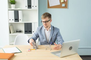 Ofis, iş adamları, sonu kavramı - Yöneticisi çalışmaları sırasında Oyuncak süpermarket arabası ile ofiste ile oynuyor