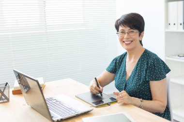 Illustrator uygulaması, web tasarımcısı ve sanatçı kavramı - grafik tasarımcı parlak bir ofiste onun kalem tablet kullanma