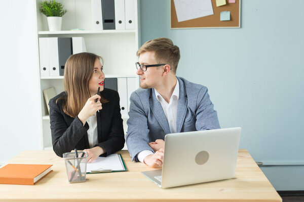 Business, team work and people concept - woman and man are discussing their project together in office