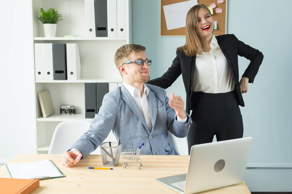 Office, business people and tired concept - woman is looking at the man who resting the game during working