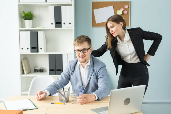 Office, business people and tired concept - woman is looking at the man who resting the game during working