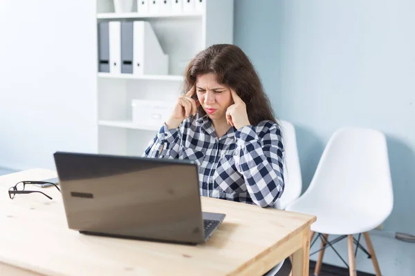 Giovane donna ha mal di testa mentre lavora sul computer portatile in ufficio — Foto Stock