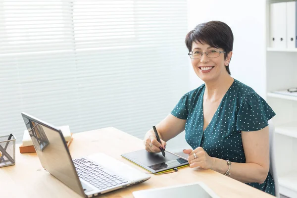 Illustrator uygulaması, web tasarımcısı ve sanatçı kavramı - grafik tasarımcı parlak bir ofiste onun kalem tablet kullanma