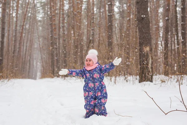 幼年期および人々 のコンセプト - 冬の屋外を歩いて、雪を投げて女の赤ちゃん — ストック写真