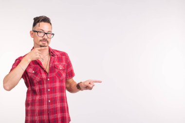 İnsanlar, stil ve moda kavramı - kopya alanı üzerinde işaret beyaz arka plan üzerinde kırmızı tişörtlü genç yakışıklı adam
