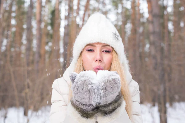 Ragazza di Natale. Inverno giovane donna soffia neve nella natura invernale — Foto Stock