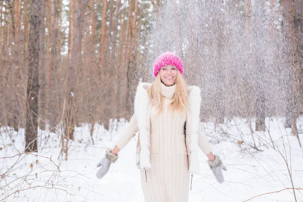 Ritratto di giovane donna che getta la neve. Ragazza sorridente che cammina in un parco invernale e si diverte in una fredda giornata di sole all'aperto — Foto Stock