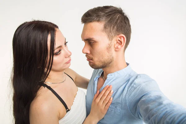 Conceito de relacionamento e família - casal engraçado feliz tomando selfie no fundo branco — Fotografia de Stock