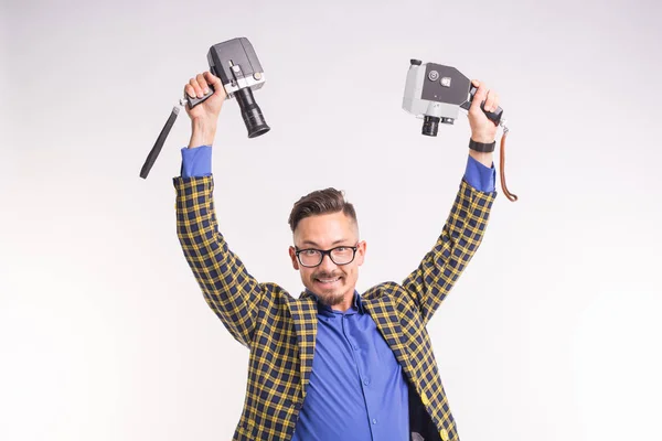 Tecnologías, fotografía y concepto de personas - retrato de un joven moreno divertido tomando selfie con dos cámaras sobre fondo blanco — Foto de Stock