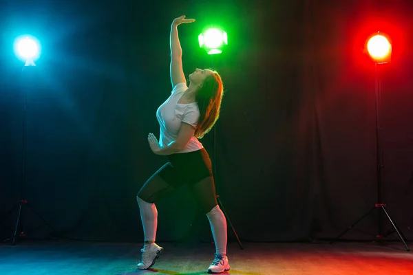 Hip-hop, jazz-funk, tecktonik, waacking, trance y street dances concepto - Mujer bonita bailando jazz funk sobre fondo oscuro — Foto de Stock