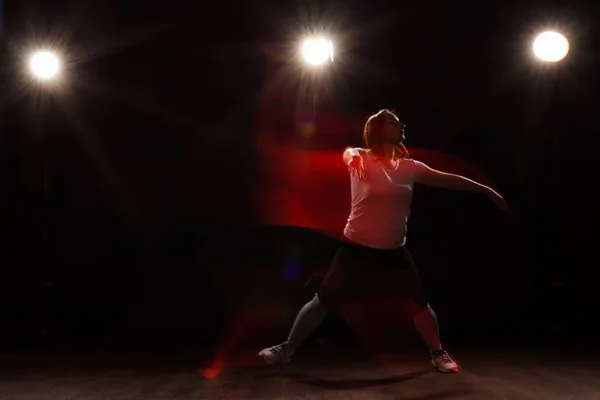 Baile, deporte, hermoso y concepto de la gente - mujer joven bailando en la oscuridad saltó en la luz colorida — Foto de Stock