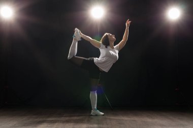 Dansı, hip-hop, caz funk ve insanlar kavramı - esnek genç kadın karanlıkta ışık altında dans