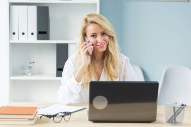 Çalışma, iş, teknoloji ve insan kavramı - laptop izliyor ve telefonu konuşurken genç kadın
