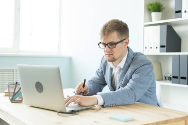 Tasarımcı, sanatçı ve web tasarım konsepti - ofiste dijital kalem tablet ve dizüstü bilgisayar kullanan genç adam portresi.