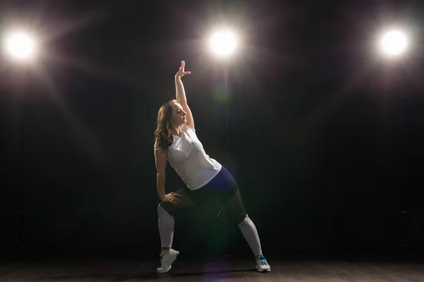 Concepto de danza, hip-hop, jazz funk y gente: una joven flexible que baila en la oscuridad bajo la luz — Foto de Stock