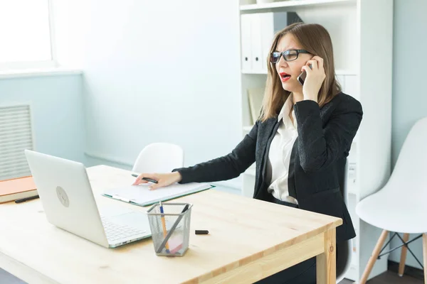 Concept d'affaires, d'agent immobilier et de personnes - Femme attrayante au bureau parlant au téléphone et prenant des notes — Photo