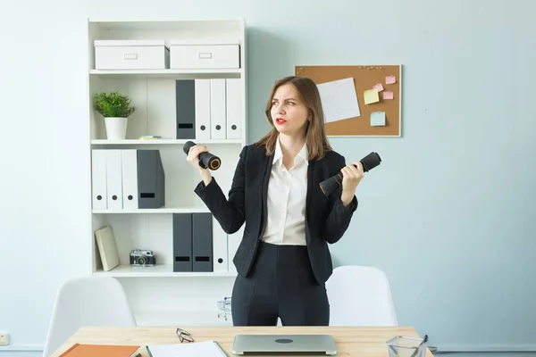 Concepto de oficina, fitness y gente - Mujer de negocios trabajando y haciendo deporte en su oficina — Foto de Stock