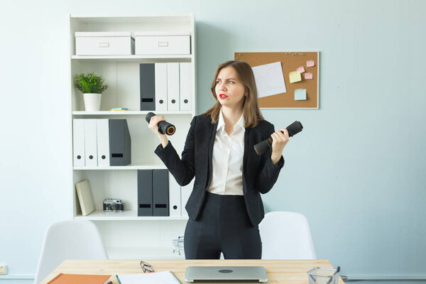 Office, fitness and people concept - Business woman working and doing sport at her office