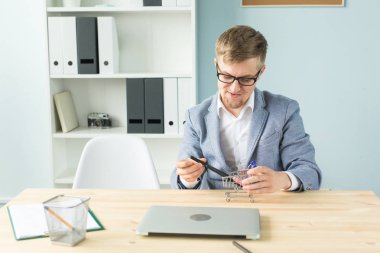 Ofis, iş adamları, sonu kavramı - Yöneticisi çalışmaları sırasında Oyuncak süpermarket arabası ile ofiste ile oynuyor