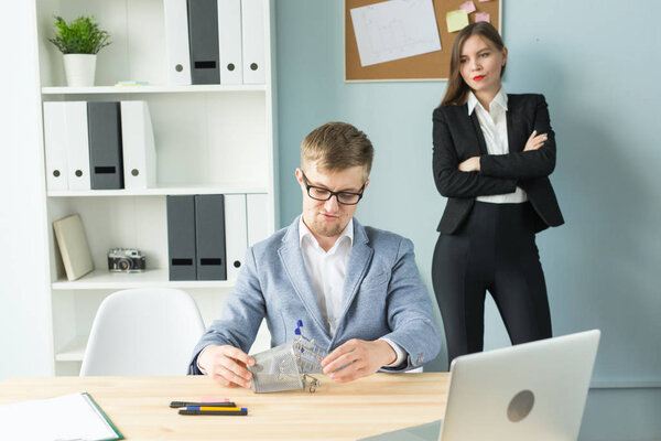 Business, emotions and people concept - Disgruntled boss watch as the employee works.