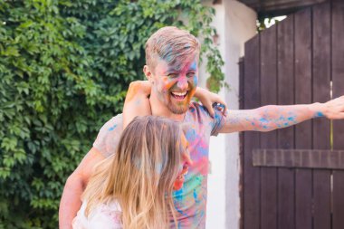 Tatil, bayram ve insanlar kavramı - eğleniyor çift ahşap kapı yakınındaki boya kaplı