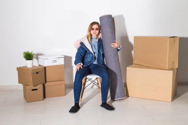 Yer değiştirme, yeni ev ve gayrimenkul konsept - yeni düz genç kadın upacking