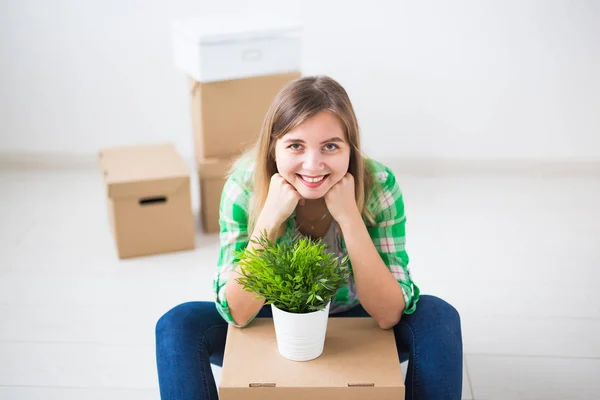 Relocation, new home and real estate concept - Young woman upacking in new flat