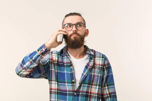 Concepto de tecnologías, moda y personas - Hombre fresco con barba usando el teléfono sobre fondo blanco — Foto de Stock