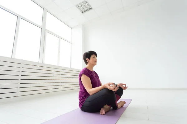 Harmony, people concept - middle aged woman doing yoga meditation
