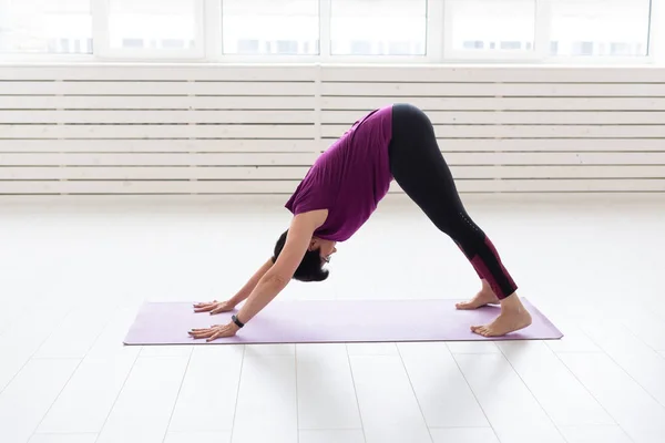 Yoga, concepto de personas - una mujer de mediana edad haciendo un yoga en el gimnasio —  Fotos de Stock