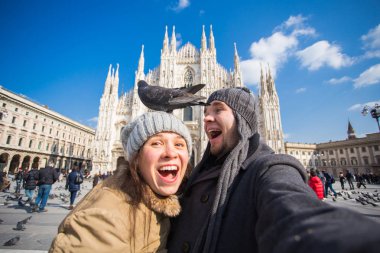 Milano Duomo Meydanı'nda güvercin ile kendi kendine portre çekici çift. Kış seyahat ve ilişki kavramı