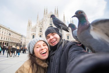 Milano Duomo Meydanı'nda güvercin ile kendi kendine portre çekici çift. Kış seyahat ve ilişki kavramı