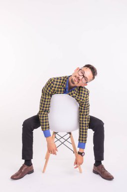 Moda ve insanlar kavramı - yakışıklı beyaz arka plan üzerinde sandalye üzerinde oturan kendine güvenen adam sakallı