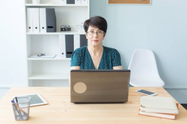 İş insan ve teknoloji kavramı - laptop çalışan orta yaşlı kadın