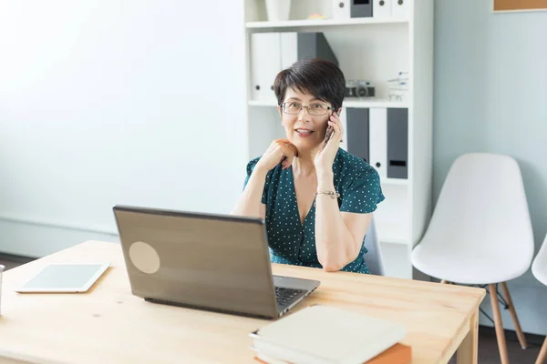 Menschen, Technologie und Kommunikationskonzept - Frau mittleren Alters greift zum Smartphone — Stockfoto