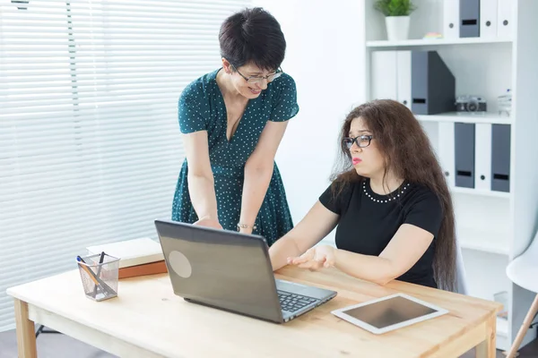 Geschäftsleute, Technik und Kommunikationskonzept - Dame mittleren Alters hilft ihrer Kollegin mit Laptop — Stockfoto