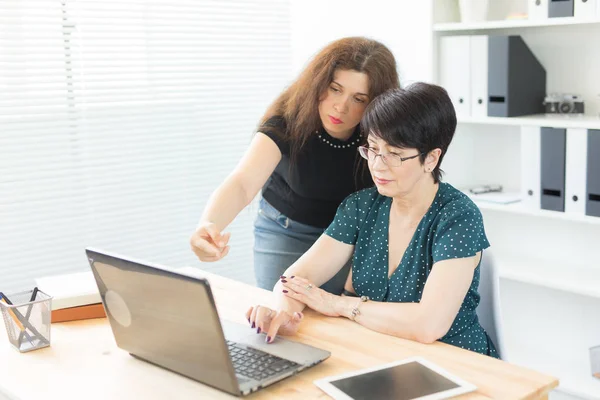 Menschen, Technologie und Kommunikationskonzept - Frau mittleren Alters und junge Frau arbeiten zusammen — Stockfoto