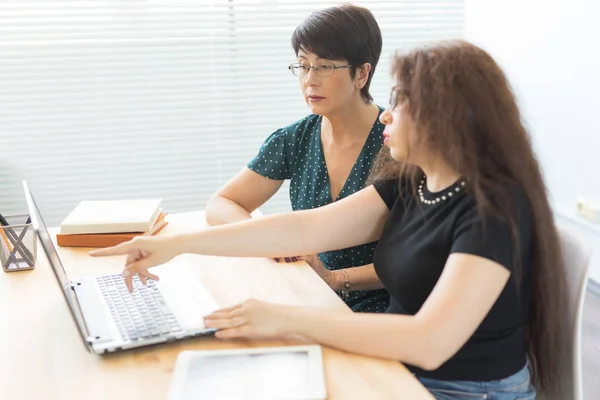 Two business women working together in office interior