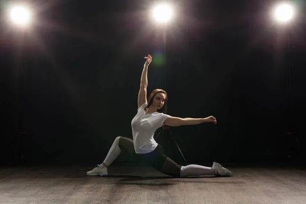 Concepto de danza, hip-hop, jazz funk y gente: una joven flexible que baila en la oscuridad bajo la luz — Foto de Stock